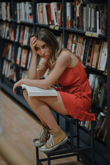 Young woman sitting on book