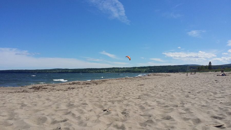 Scenic view of beach against blue sky