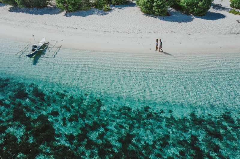 Drone view of couple at beach on sunny day