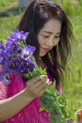 Close-up of woman holding purple flowering plant