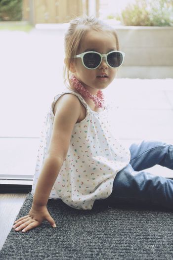 Cute girl sitting on sunglasses
