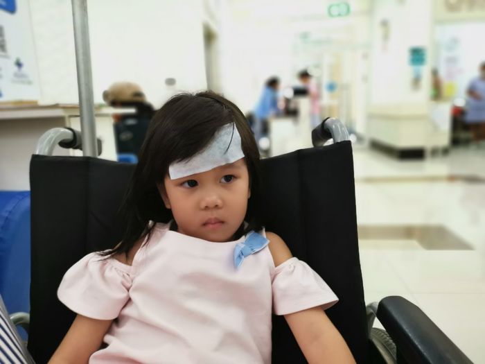 Girl sitting on wheelchair in hospital