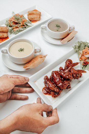 Cropped hands of person arranging food on table