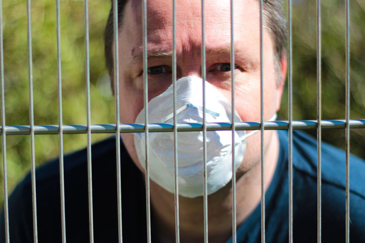 Portrait of young man seen through fence