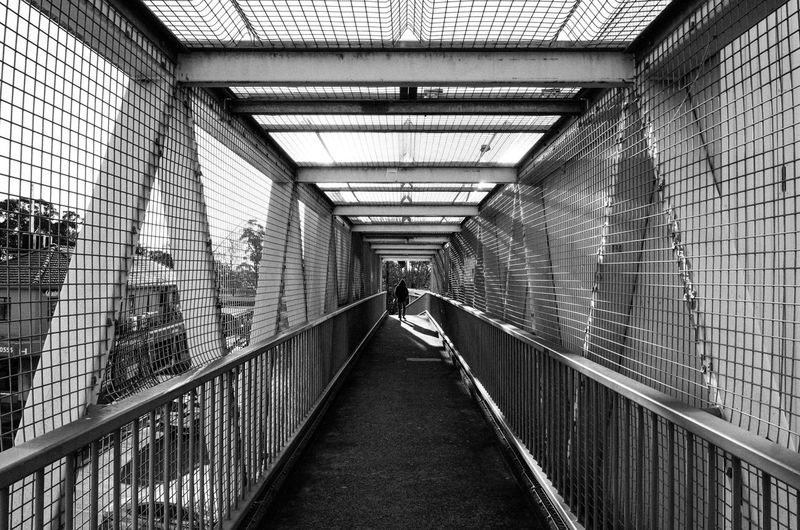 Woman walking on footbridge in city