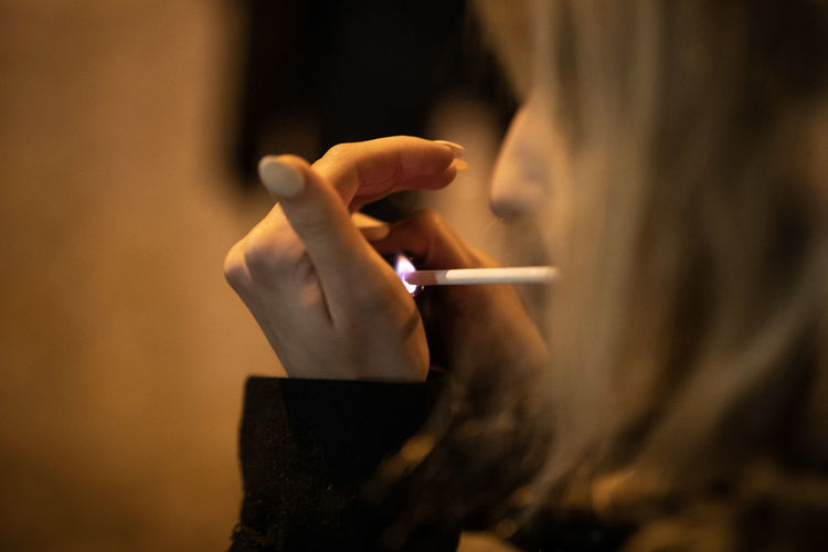 Close-up of woman igniting cigarette