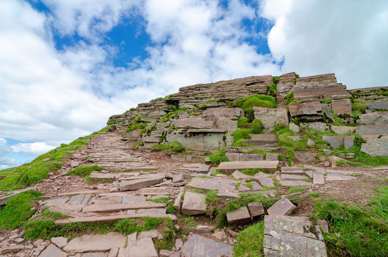 Low angle view of old ruin building against cloudy sky