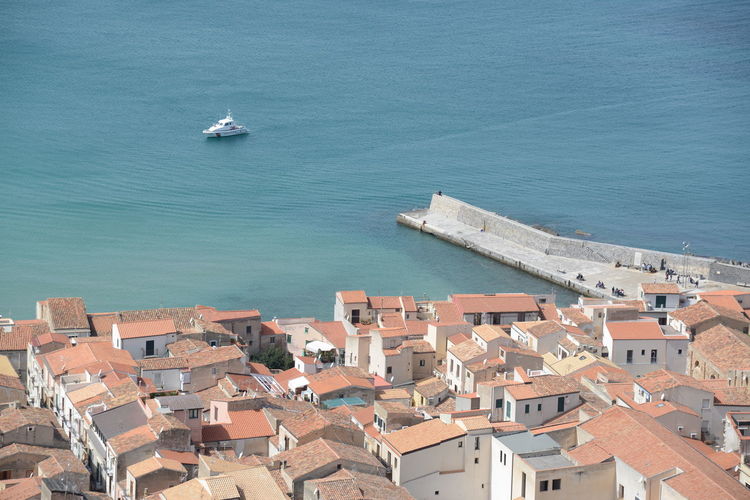 High angle view of townscape by sea against buildings