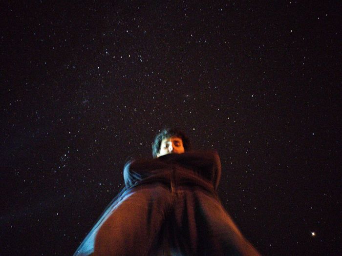 Portrait of man standing against sky at night