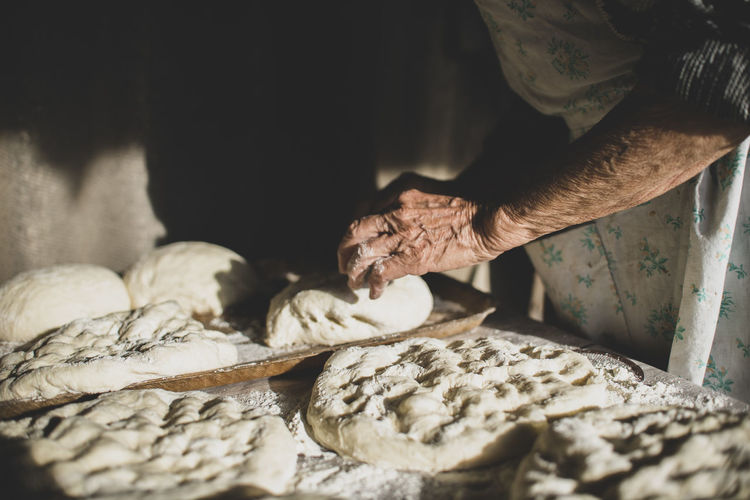 Georgian old woman is baking a bread