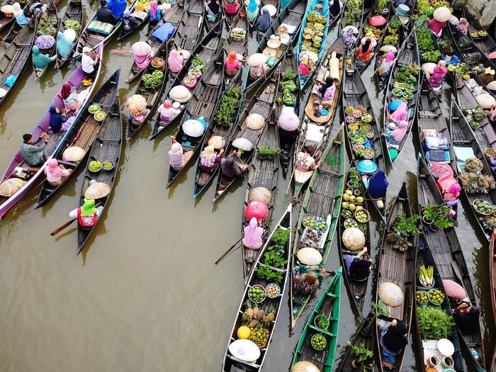 High angle view of market vendors sitting on rowboats in lake