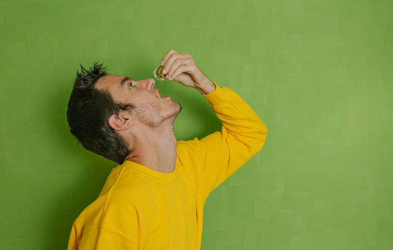 Portrait of man standing against yellow wall