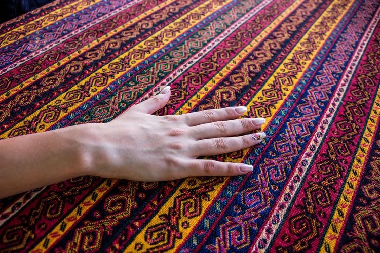 Cropped hand of woman touching patterned fabric