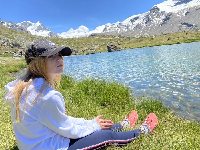 Young woman with arms raised against mountains