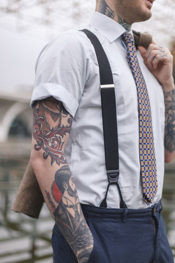 Hipster man with tattoo standing outdoors