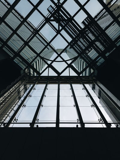 Low angle view of building through glass ceiling 