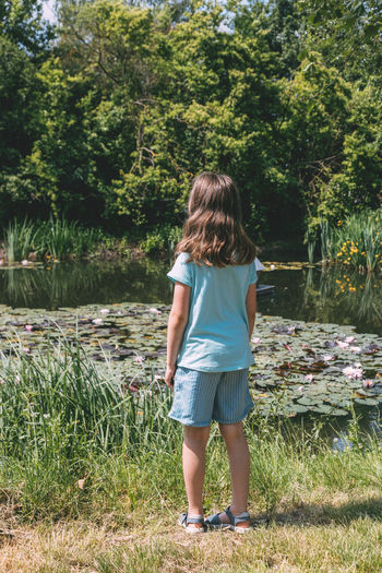 A cute girl stands on the banks of a river  in thought or admires nature.holidays in the village