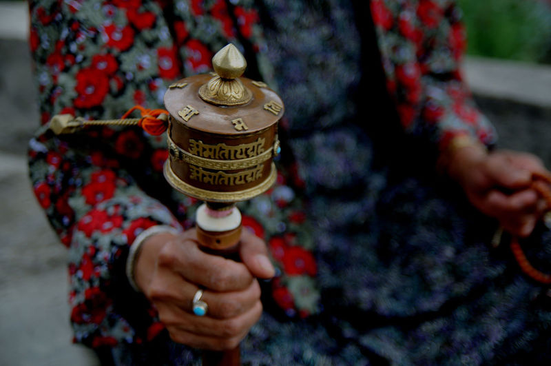 A lady spins a prayer wheel. bhutan is a buddhist country. arindam mukherjee.