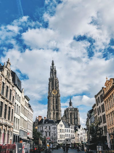Low angle view of buildings in antwerp against cloudy sky