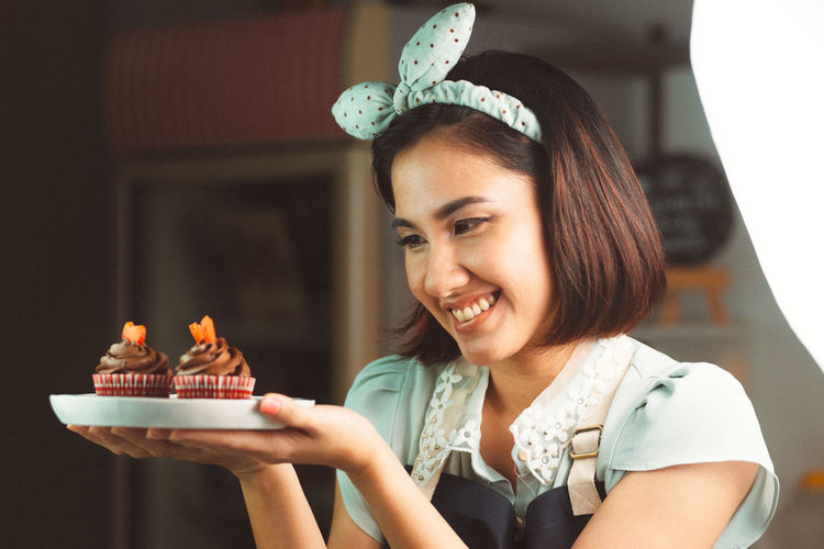 Portrait of smiling woman holding cake
