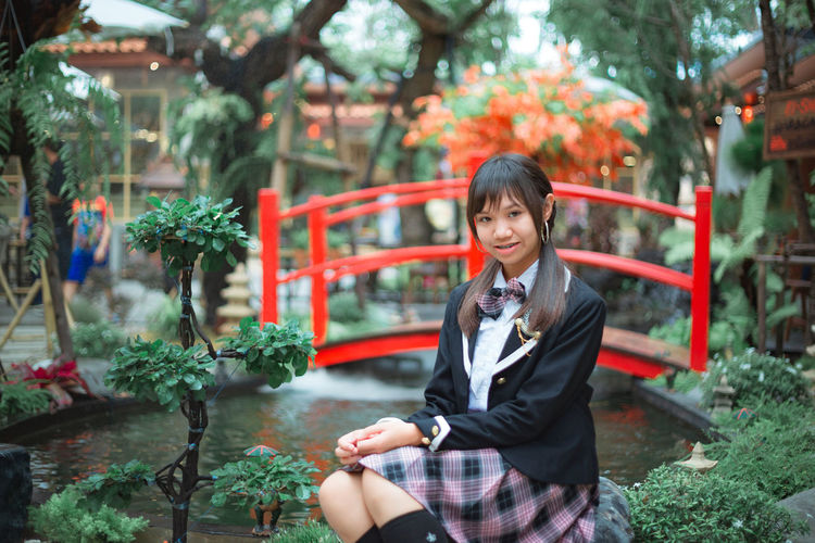 Portrait of teenage girl sitting at park