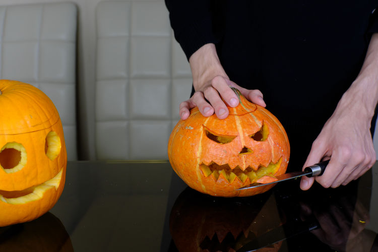 Midsection of man holding pumpkin during halloween