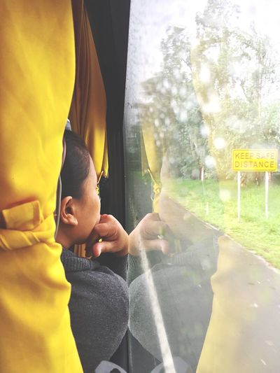 Boy sitting in glass window