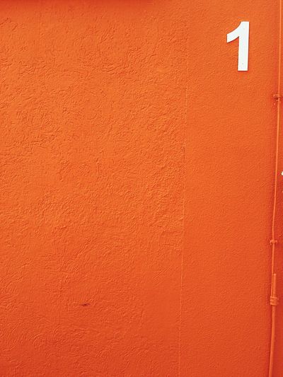 Close-up of orange wall with number 1