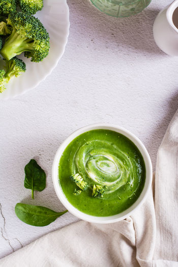 Bowl with broccoli cream soup on the table. healthy food. top and vertical view