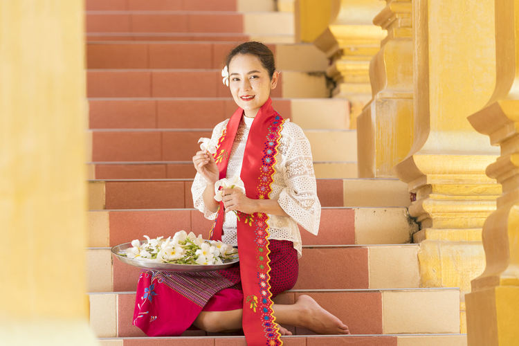 Portrait of smiling young woman sitting on steps