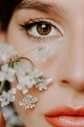 Close-up portrait of woman by flowers