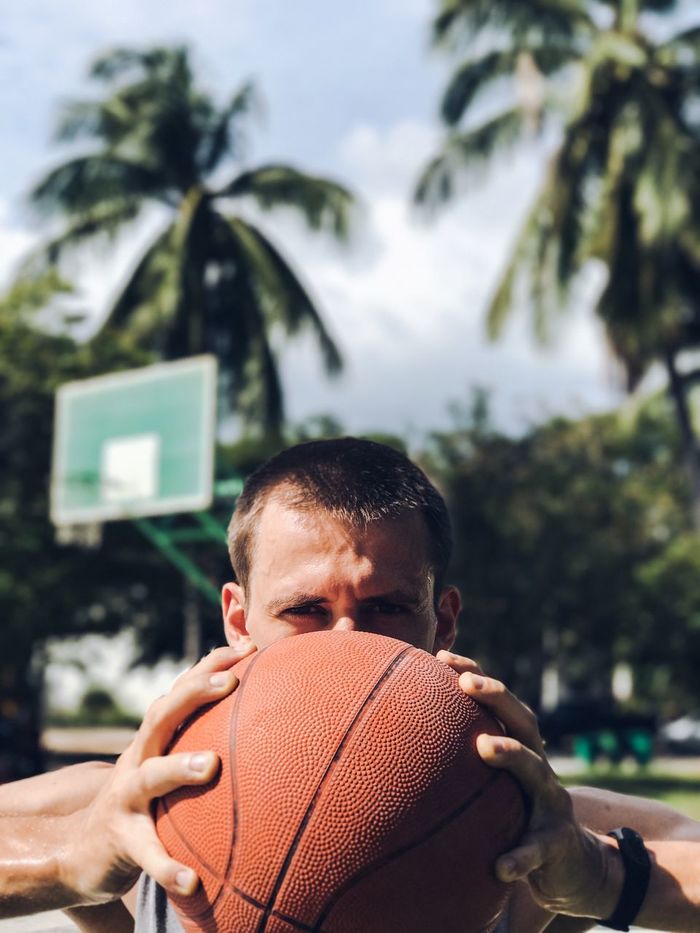 Close-up portrait of a man holding basketball