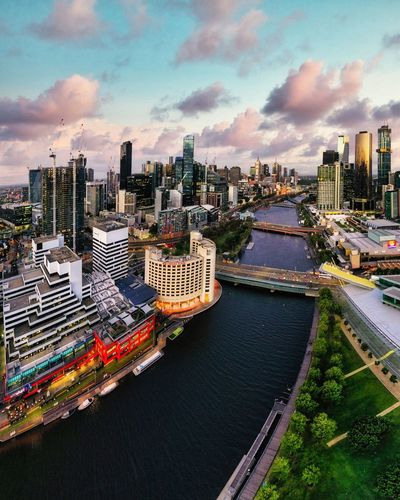 Aerial view of yarra river amidst the melbourne skyscrapers at sunset