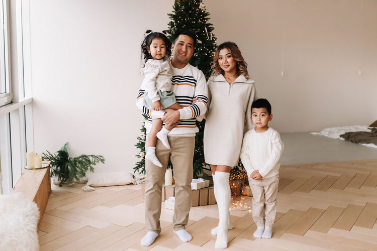 An asian multi-racial family with two children celebrate the christmas holiday in a decorated house