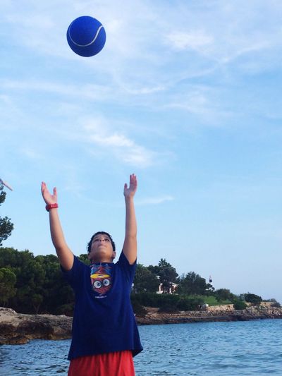 Low angle view of person standing in ball against the sky