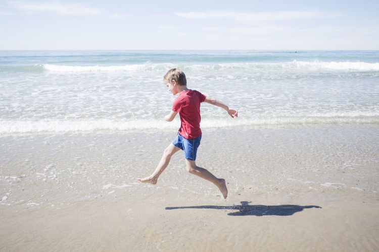 Full length of boy running on beach