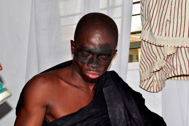 Bald man with face paint sitting at home