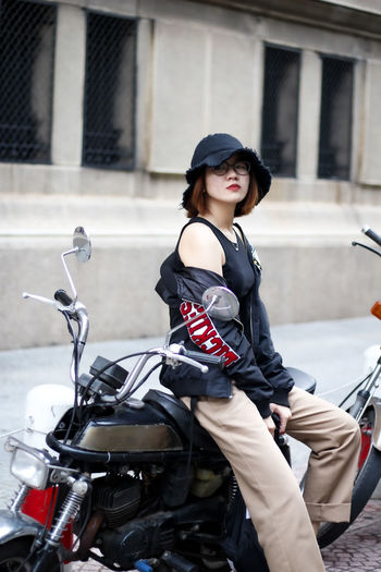 Young woman riding motor scooter on city
