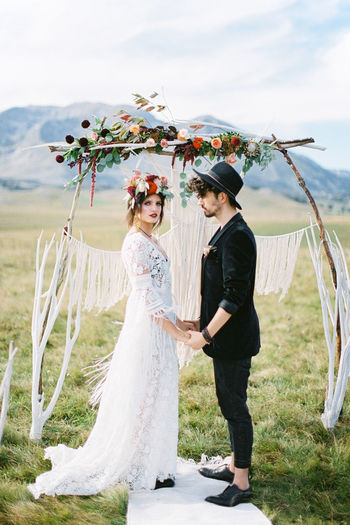 Rear view of bride and bridegroom standing by plants