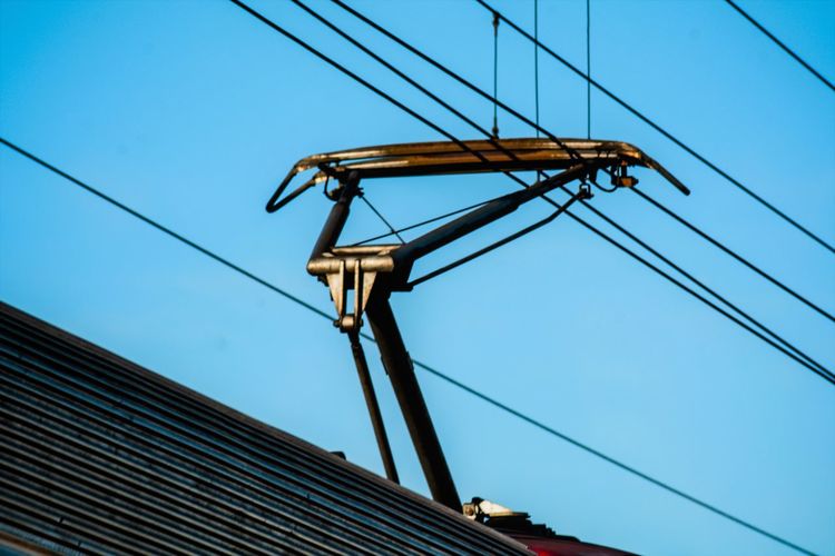 Low angle view of electic train cables against clear blue sky