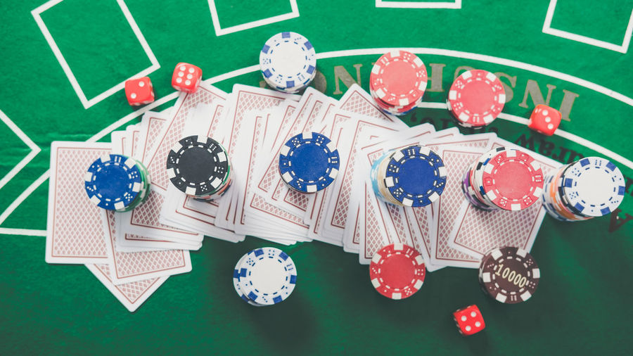High angle view of gambling chips with cards on table