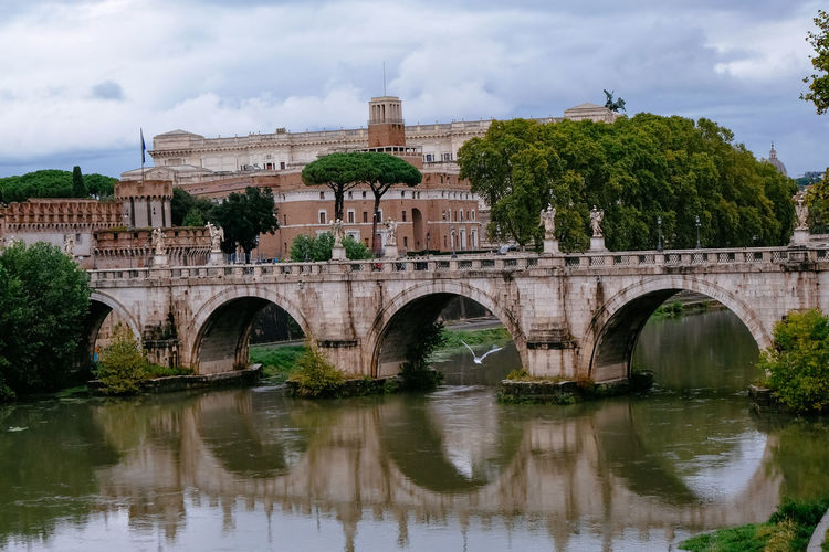 Castelo sant'angelo and ponte sant'angelo over tiber river - water reflection - rome, italy