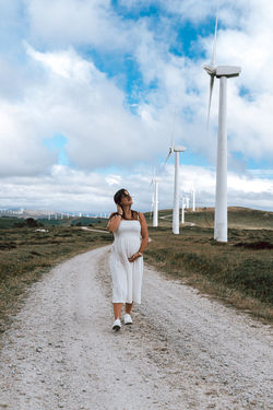 Full length of woman walking on field against sky