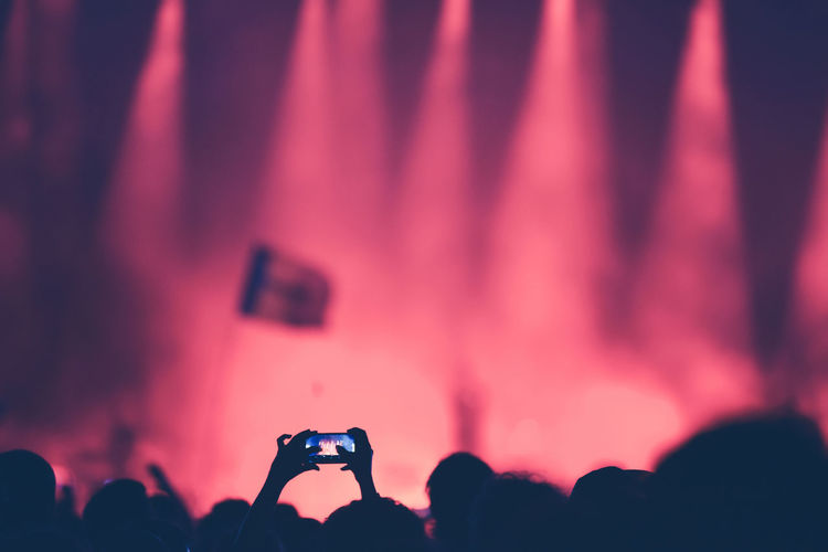 Fan taking photo of concert at festival with a smart phone