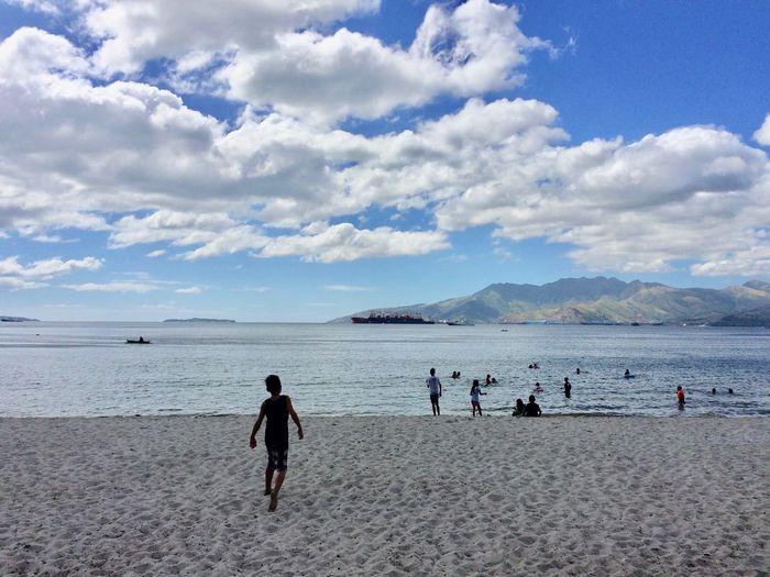 People on beach against sky