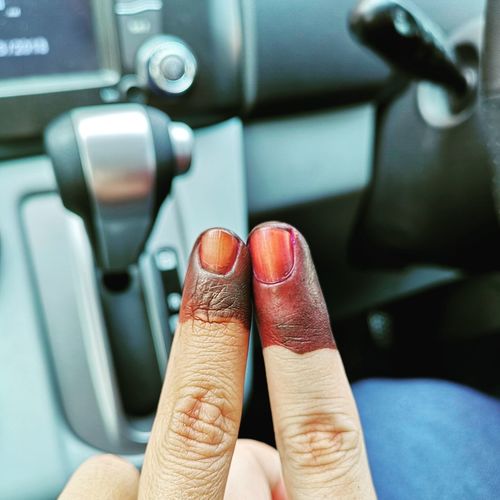 Cropped image of man and woman fingers in car