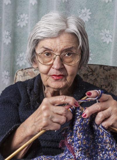 Portrait of senior woman knitting while sitting at home