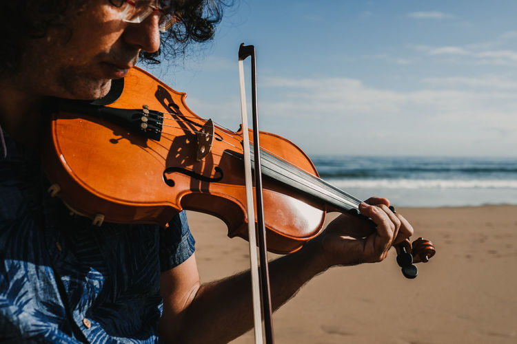 Man playing violin at beach
