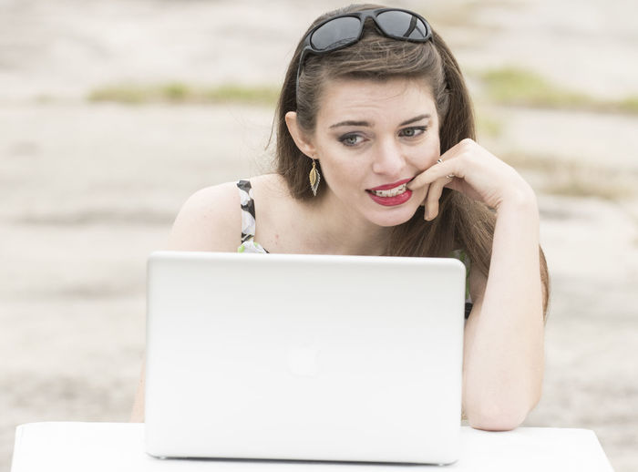 Close-up of young woman using laptop at beach