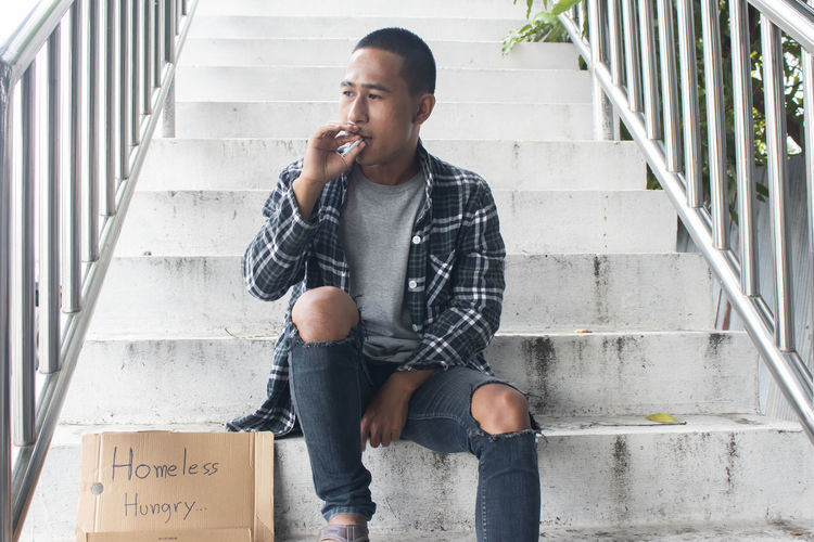 Full length of young man sitting on staircase